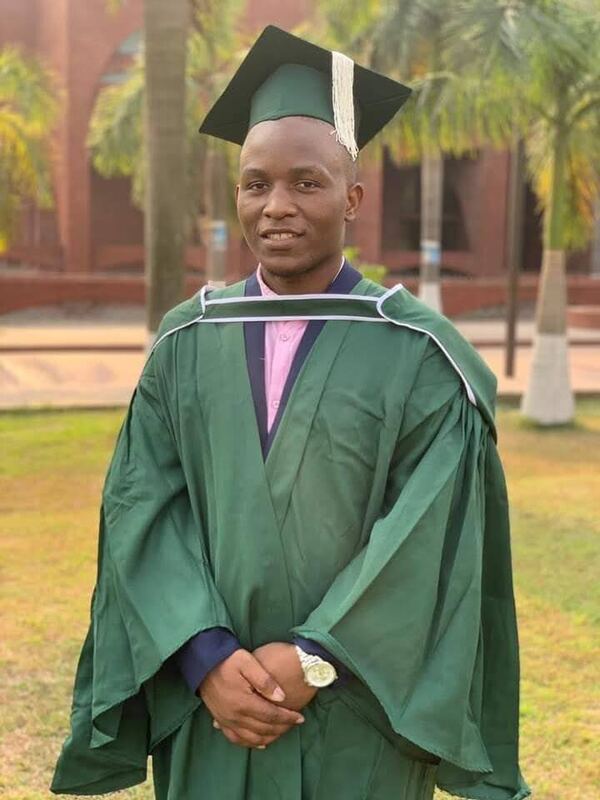 Wearing a green academic gown and cap on graduation day