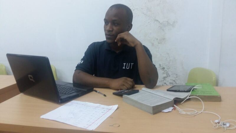 Seated at a desk in an IUT shirt with papers spread out