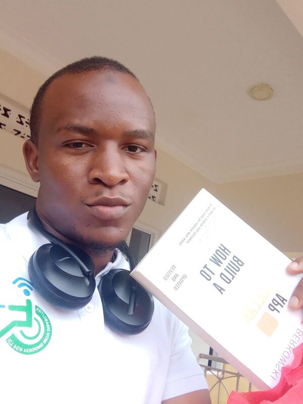 Holding a book to the camera with headphones around the neck
